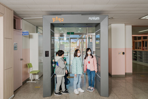 한화그룹이 '맑은학교 만들기' 캠페인을 통해 지원한 에어샤워를 통과하고 있는 서울 보라매초등학교 학생들. /사진=한화그룹