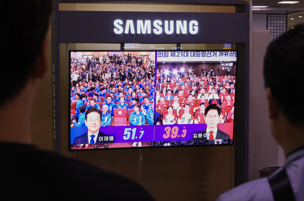 3일 오후 서울역 대합실에서 시민들이 방송3사 출구조사 결과 발표를 지켜보고 있다. 연합뉴스. 