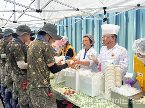 안유성 셰프(오른쪽)가 군 장병과 주민들에게 음식을 전달하고 있다.사진/나주시