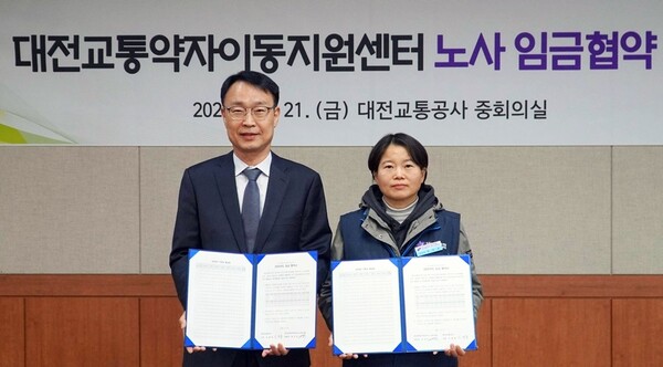 21일, 대전교통공사 이광축 사장(왼쪽)과 민주노총 대전세종지역서비스노동조합 엄자옥 위원장(오른쪽)이 임금협약을 체결 후 기념 촬영을 하고 있다. 교통공사 제공.